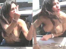 Topless woman goes wild in a moving car, shouting and screaming on the street